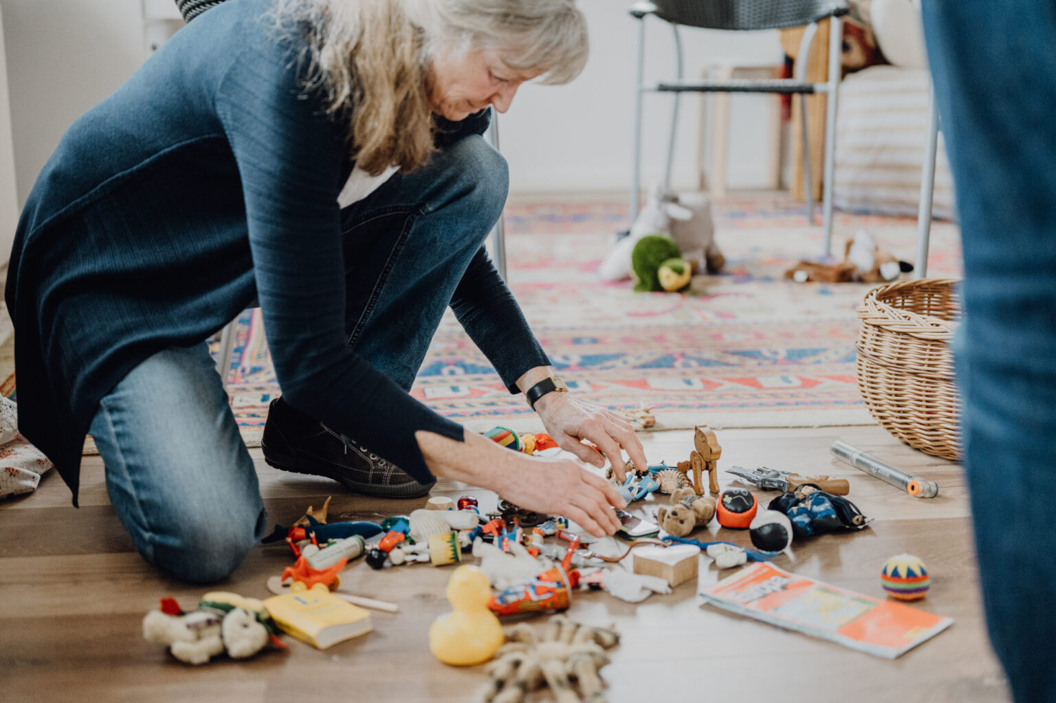 Frau arbeitet im Coaching mit Bodenankern und Materialien auf dem Teppich, um Themen räumlich darzustellen.