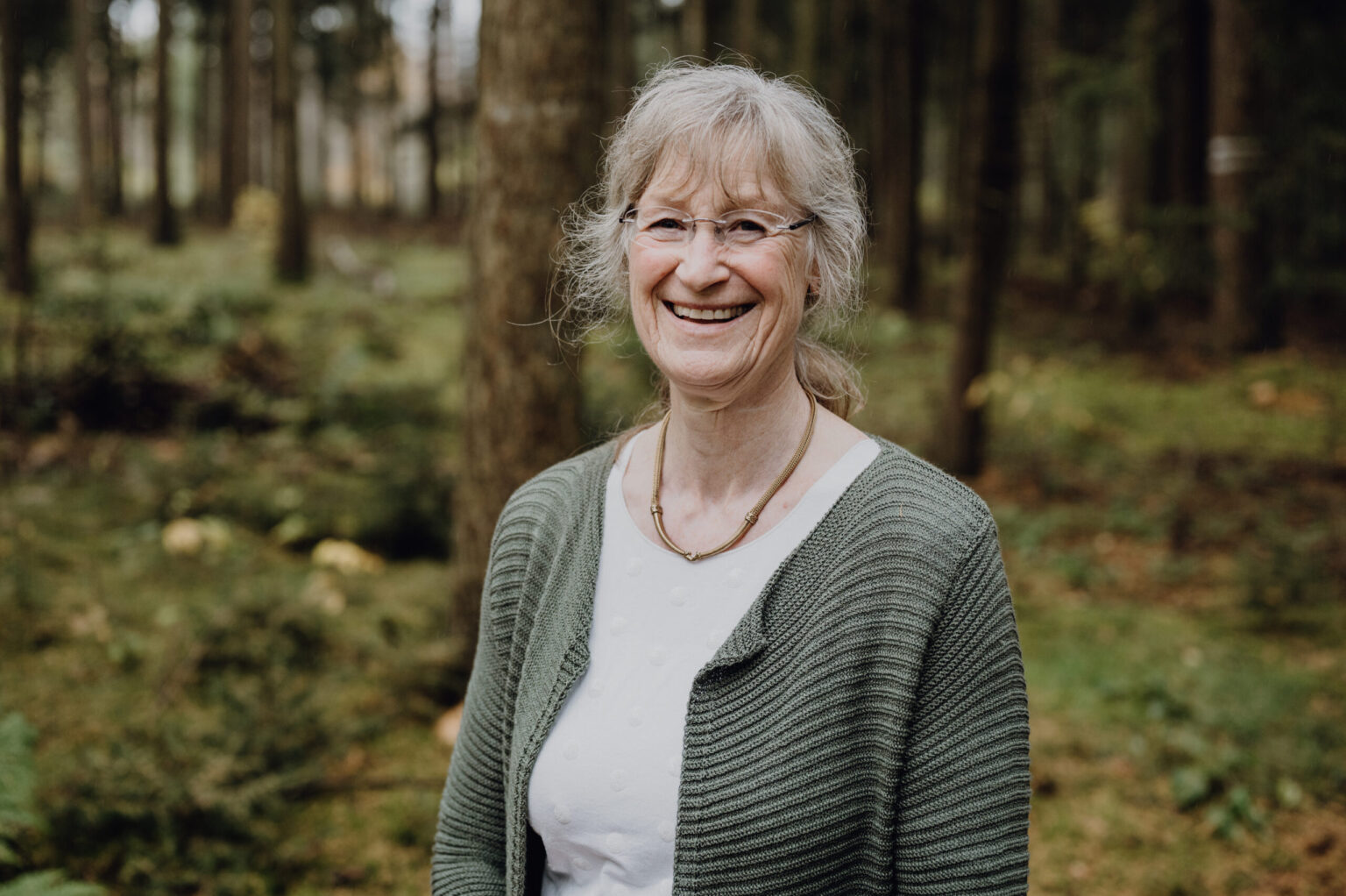 Porträt von Sabine Krüger, erfahrene Supervisorin und Coach, lächelnd in der Natur.